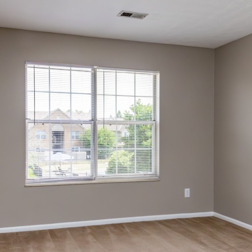 Bedroom with carpeting and large windows.